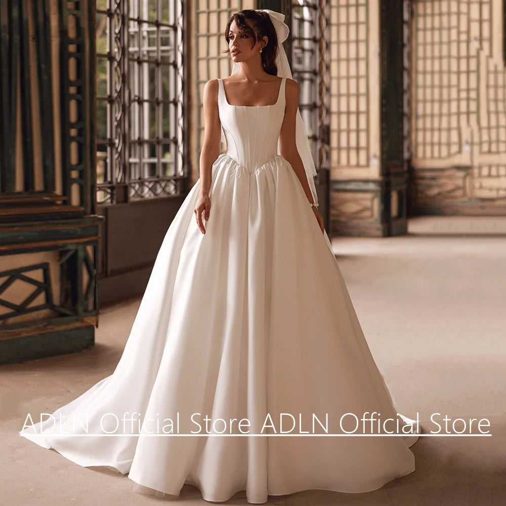 Woman in a white wedding dress standing in an elegant room with traditional decor.