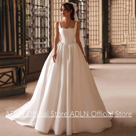 Woman in a white wedding dress standing in an elegant room with traditional decor.